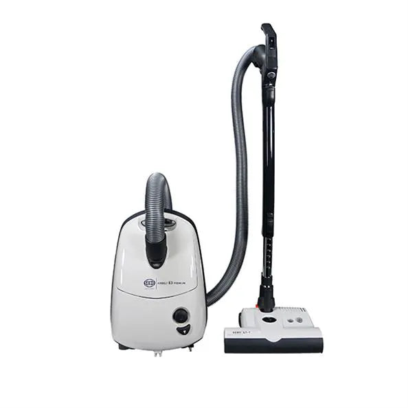 A white SEBO Airbelt E3 canister vacuum with an ET-1 Powerhead and a telescopic wand, displayed alongside its components including a hose and filters.
