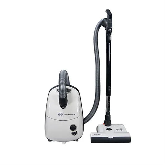 A white SEBO Airbelt E3 canister vacuum with an ET-1 Powerhead and a telescopic wand, displayed alongside its components including a hose and filters.